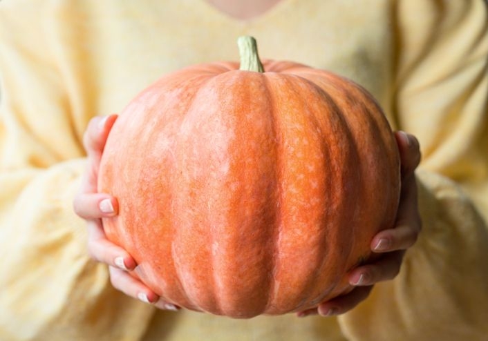 pumpkin hold by a woman